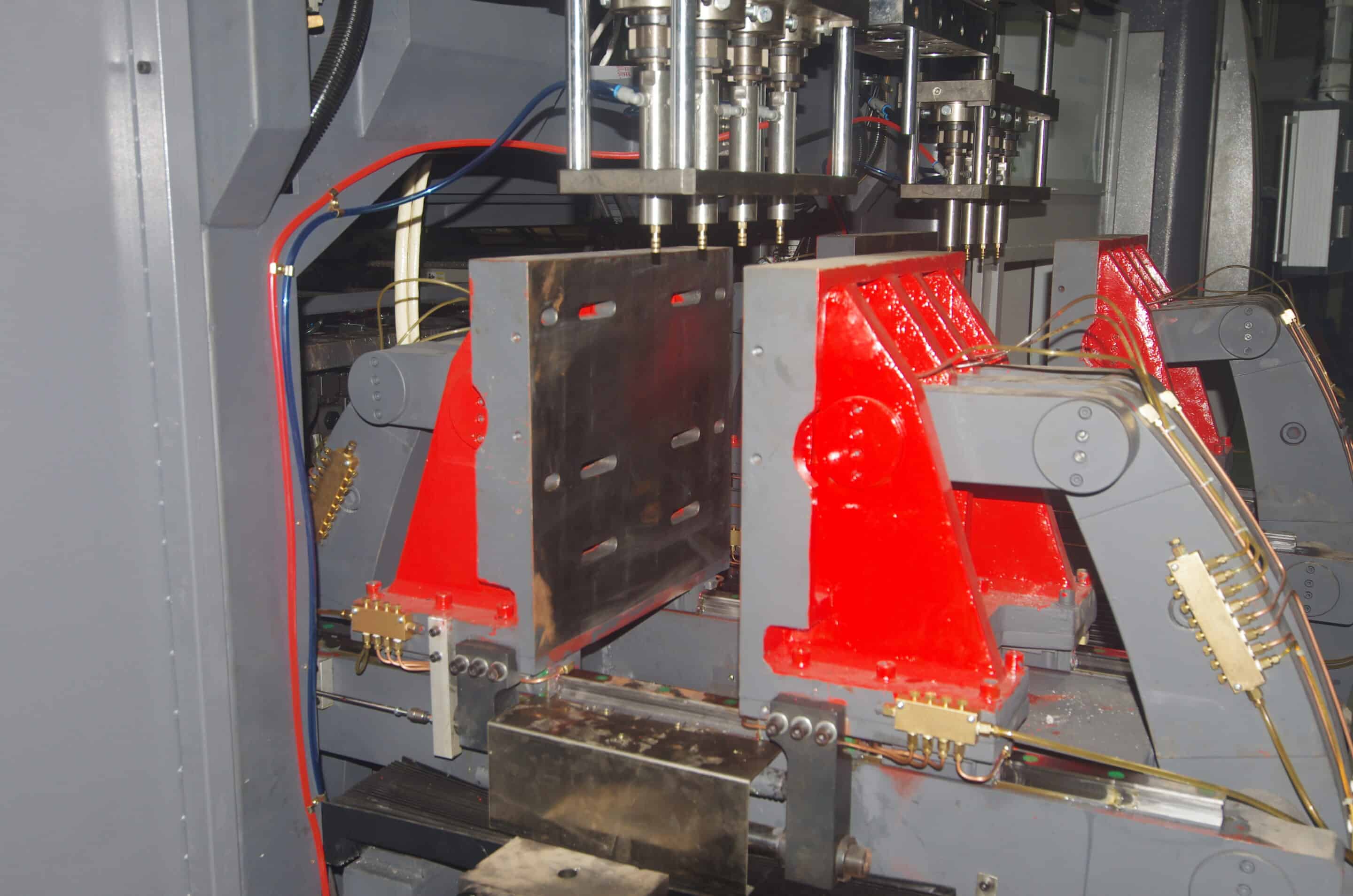 Dual clamping units with upper cutter heads and central die head inside blow molding machine