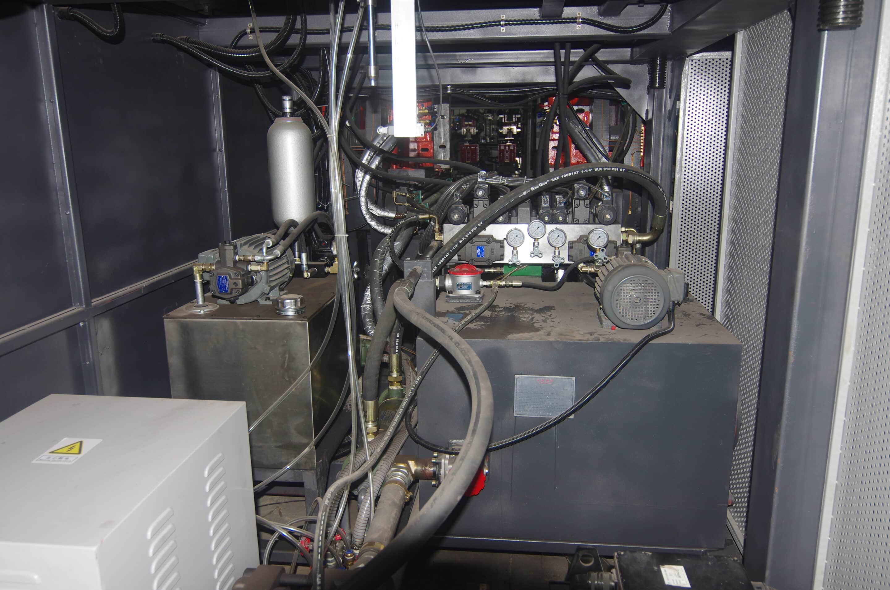 Hydraulic power unit with pump, tank, valve manifold, gauges, and hoses inside machine base