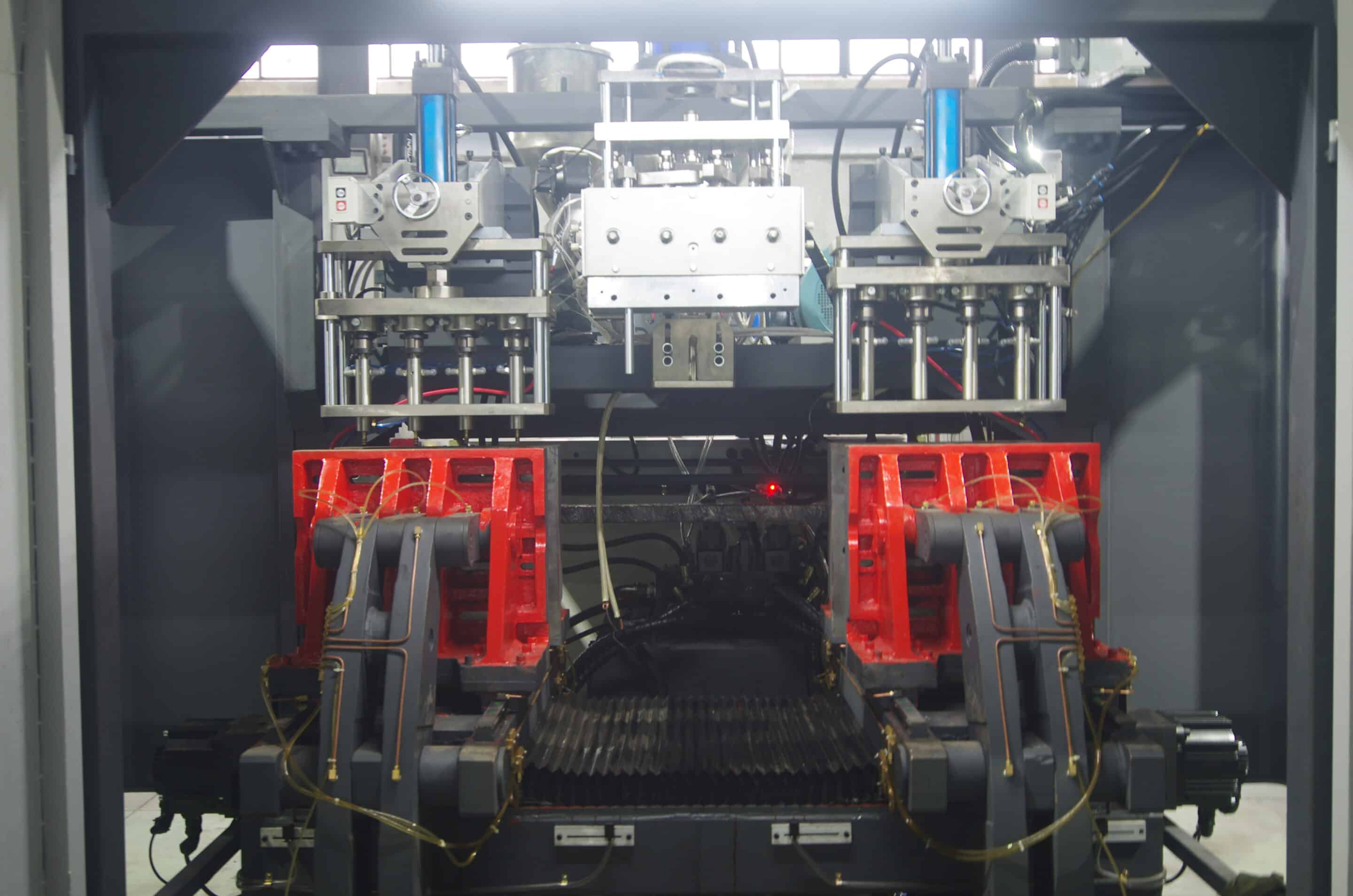 Dual clamping units with upper cutter heads and central die head inside blow molding machine