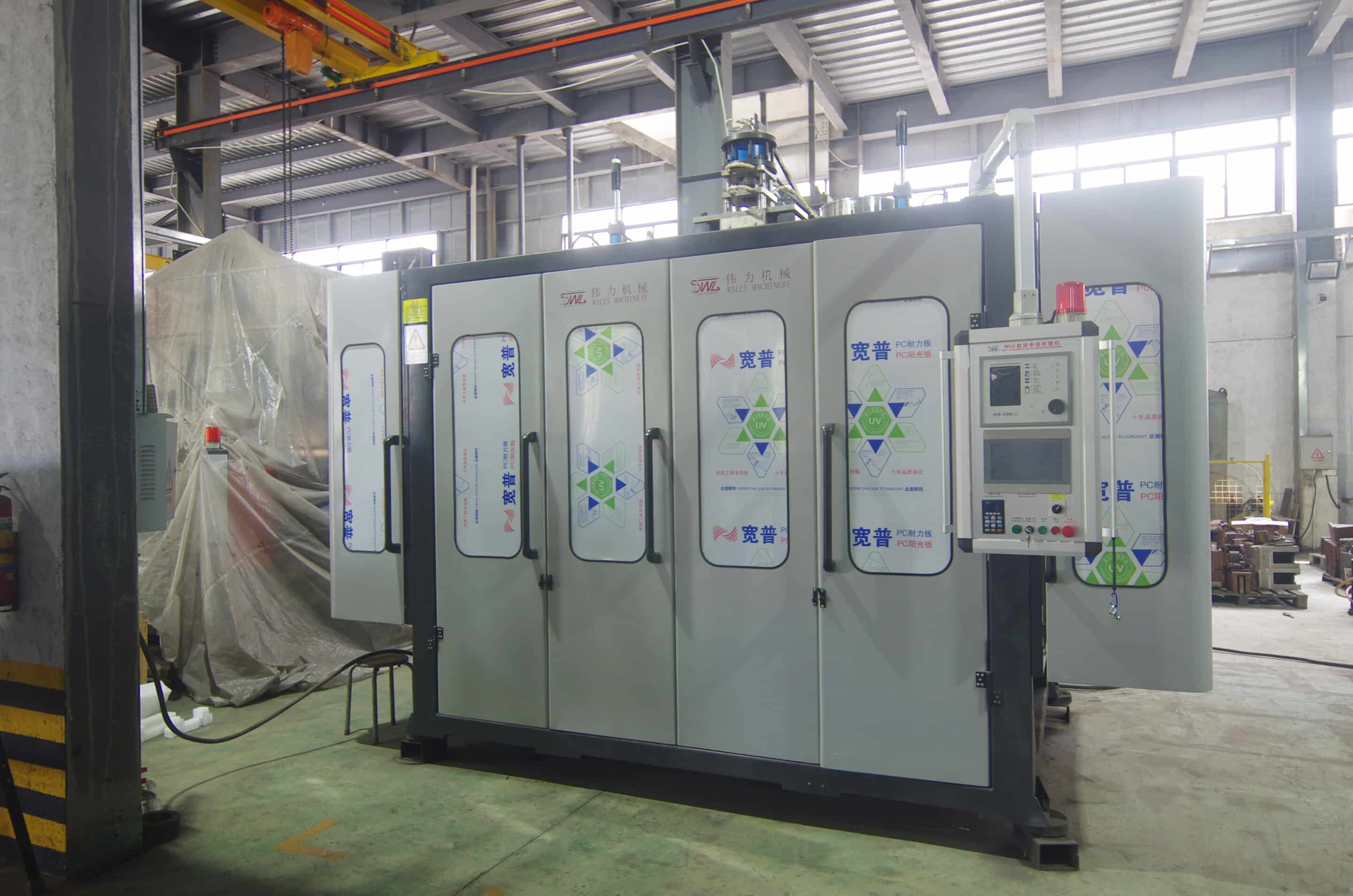 Enclosed extrusion blow molding machine cell with safety doors and side-mounted HMI in workshop