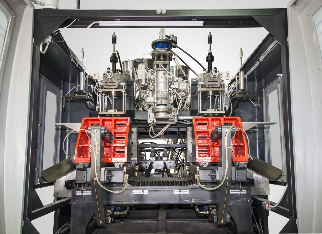 LEKA Machine FORMA H4L Series dual station extrusion blow molding machine interior with red mold assemblies