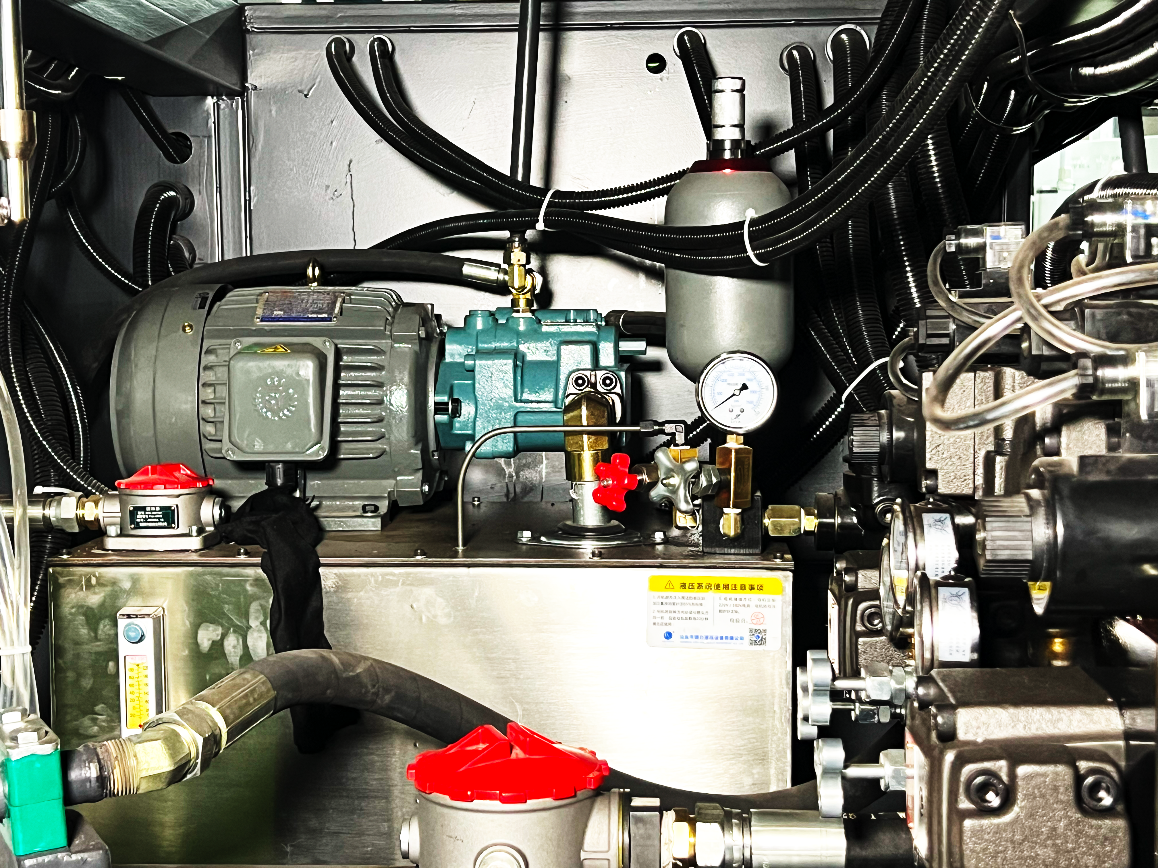 Hydraulic power unit with motor, pump, accumulator, manifold, gauges, filters, and hoses inside machine cabinet