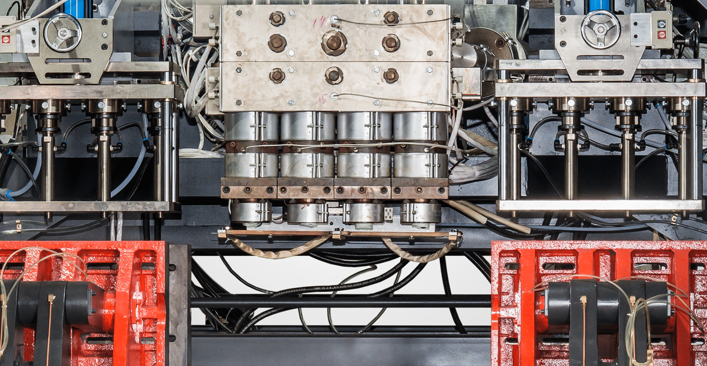 Extrusion blow molding machine four-die head manifold with band heaters, hoses, wiring harnesses, and support frames