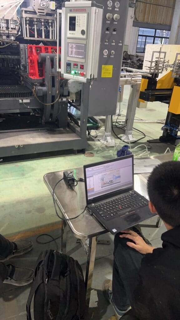 Technician using laptop to program extrusion blow molding machine control system