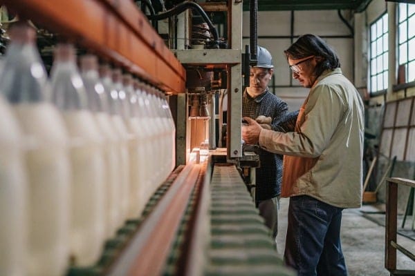 Factory workers inspecting extrusion machine operation (ID#2)
