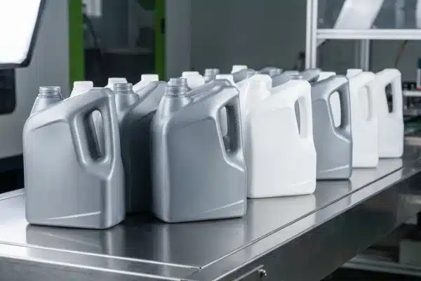 Finished HDPE household bottles after extrusion blow molding on conveyor line