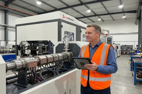 Engineer inspecting barrel heating system with PID, SSRs, cooling, interlocks (ID#1)